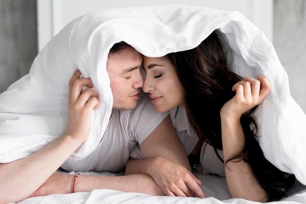Premium Photo | Front view of couple posing in bed with blanket over heads  | Couple posing, Romantic couple poses, Couples